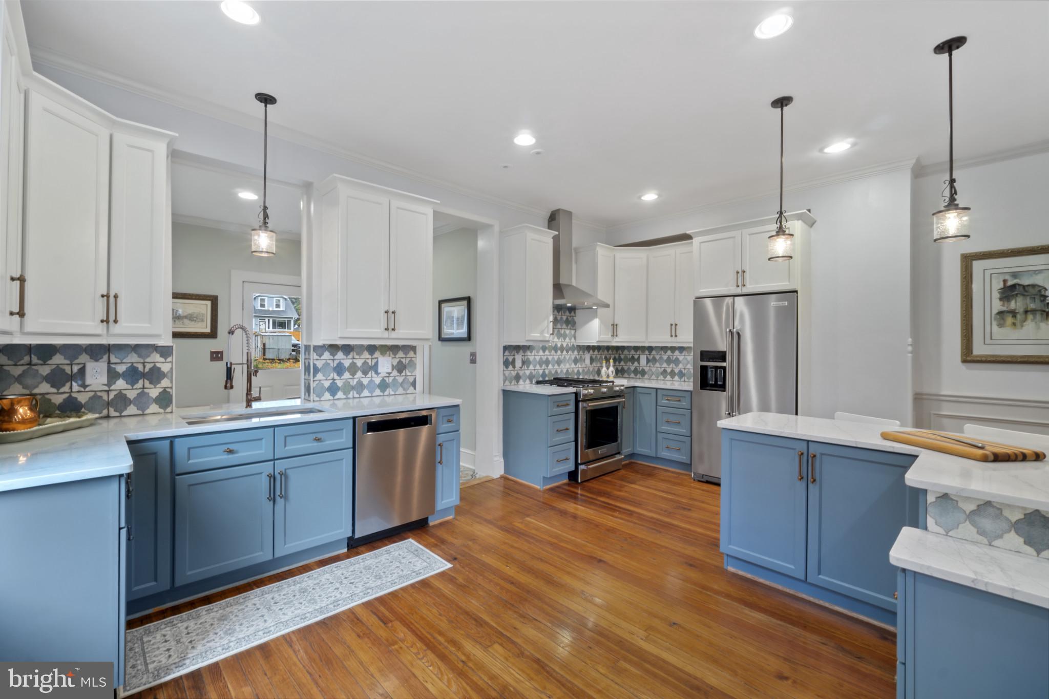 4300 Evans Chapel Road Baltimore, MD 21211 - Photo 11 of 40 a kitchen with kitchen island granite countertop wooden floors stainless steel appliances and sink