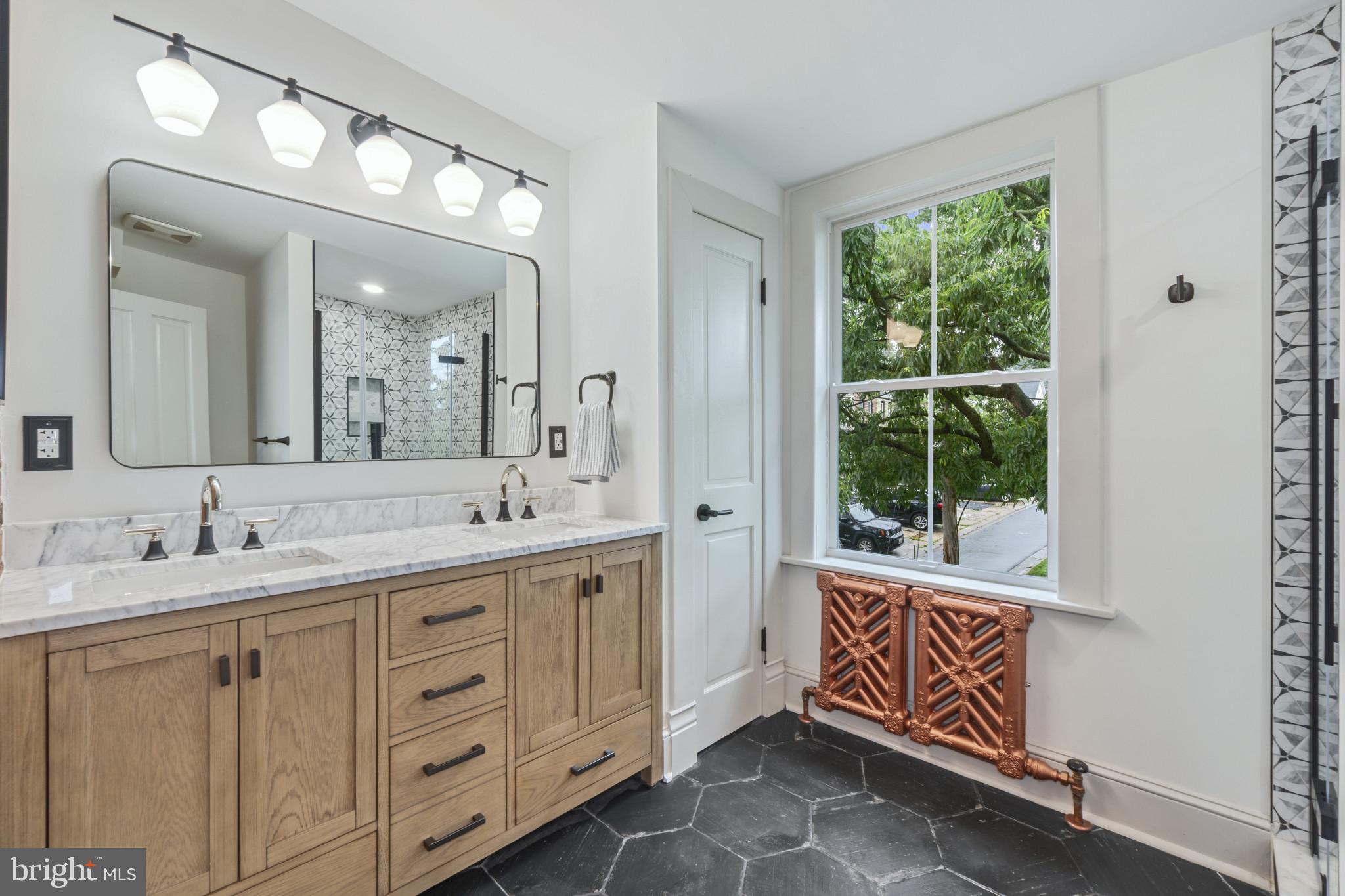 4300 Evans Chapel Road Baltimore, MD 21211 - Photo 18 of 40 a spacious bathroom with double sink a mirror a window and a shower