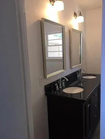a bathroom with a double vanity sink and a mirror