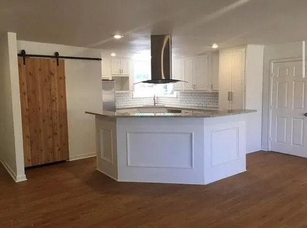 a kitchen with kitchen island granite countertop cabinets and refrigerator