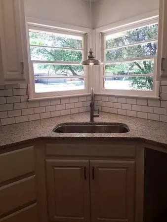 a kitchen with a sink and large window