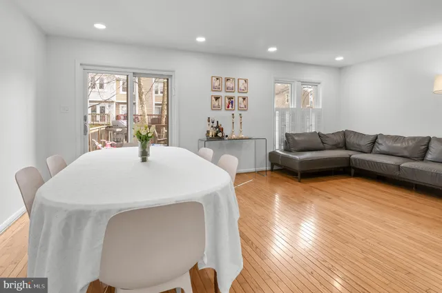 a living room with furniture a table and kitchen view