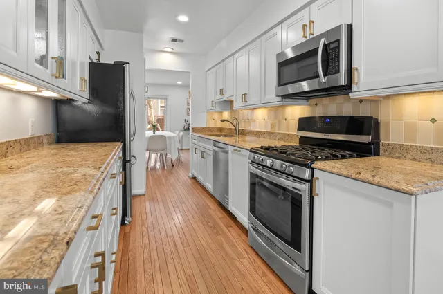 a kitchen with stainless steel appliances kitchen island granite countertop a stove a sink and a microwave