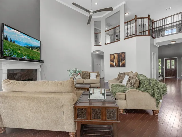 a living room with furniture a flat screen tv and a floor to ceiling window