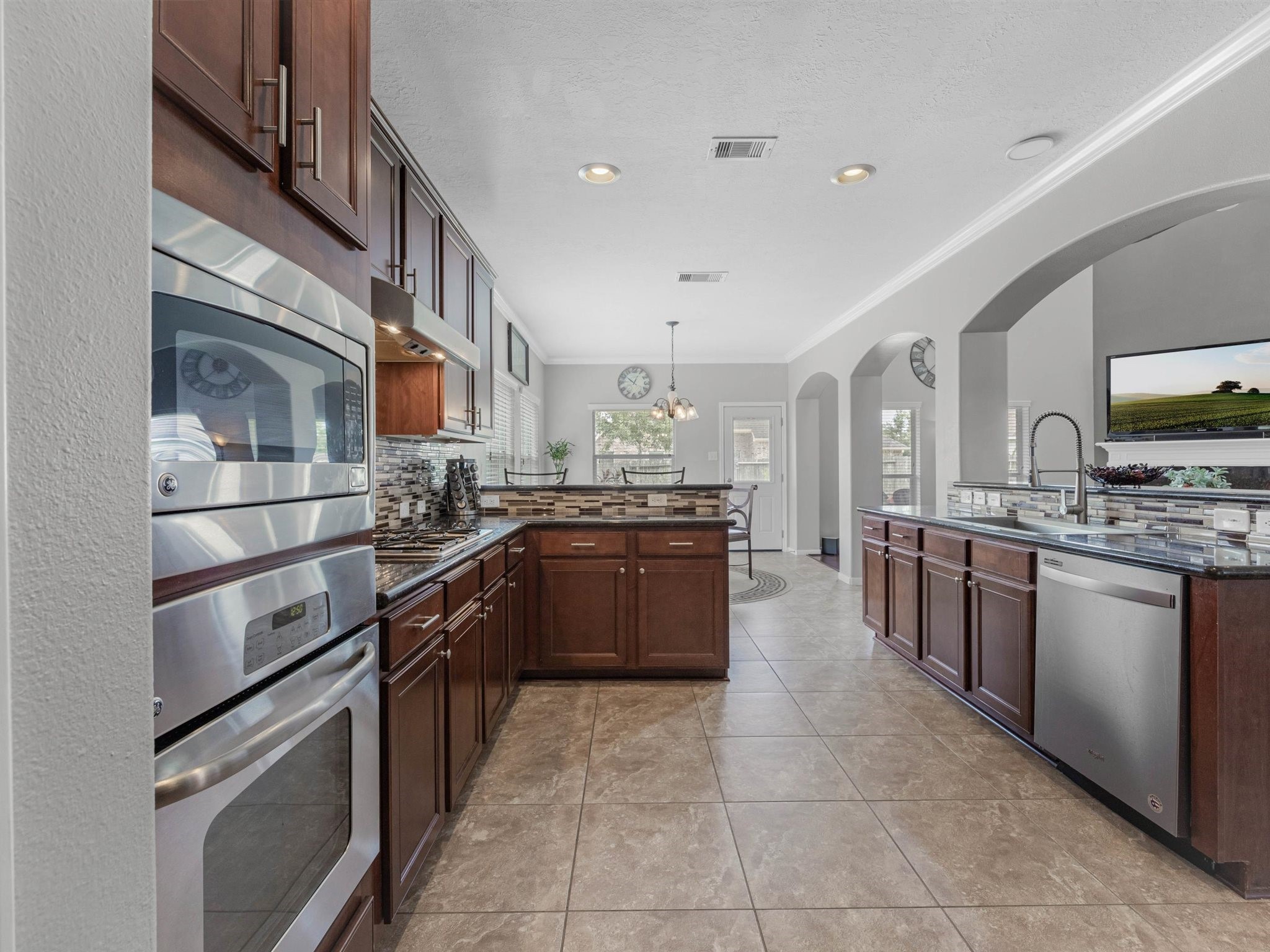 3310 Compass Court Conroe, TX 77301 - Photo 12 of 38 a kitchen with stainless steel appliances granite countertop a stove top oven and cabinets