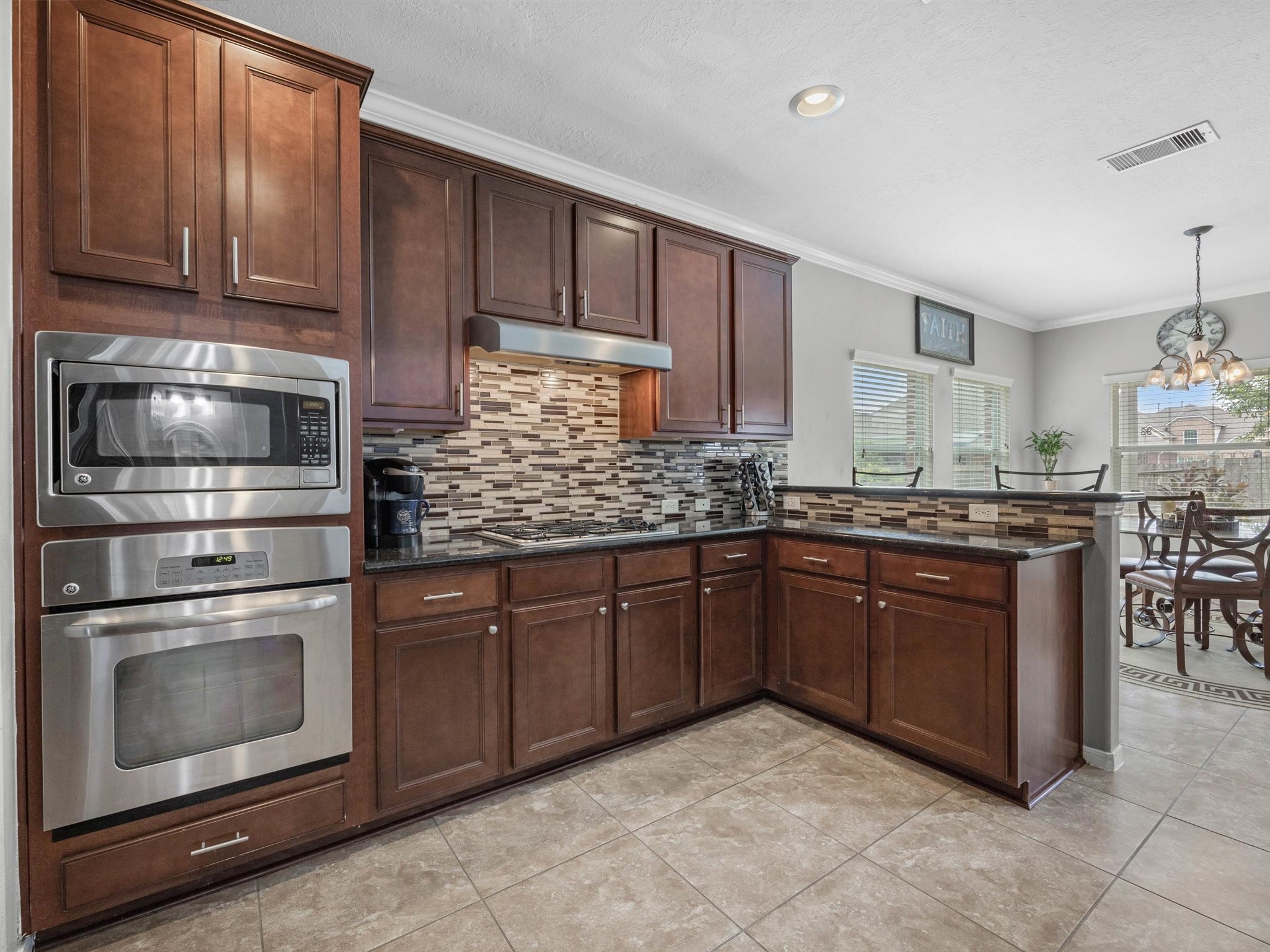 3310 Compass Court Conroe, TX 77301 - Photo 13 of 38 a kitchen with stainless steel appliances granite countertop wooden cabinets a stove a sink and dishwasher