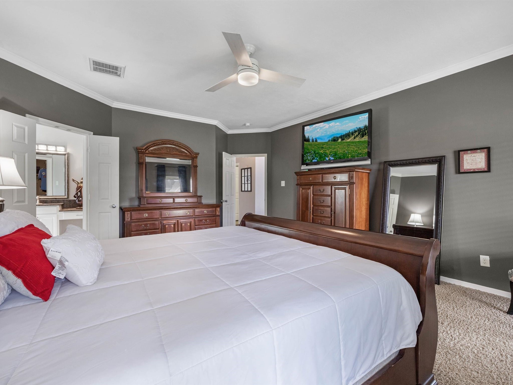 3310 Compass Court Conroe, TX 77301 - Photo 20 of 38 a bedroom with a large bed a flat tv screen and dresser