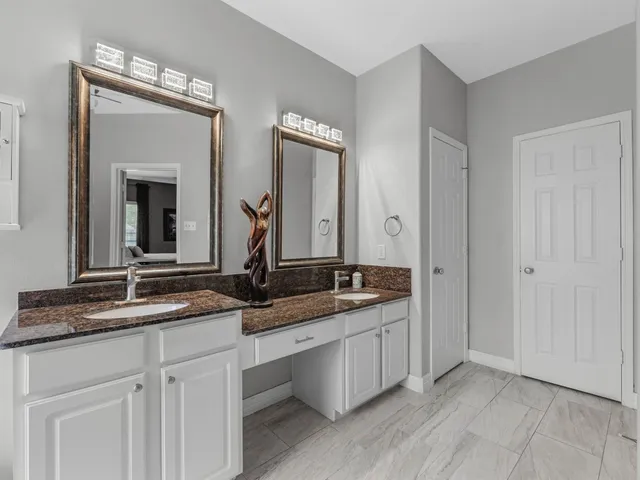 a bathroom with a granite countertop sink and a mirror