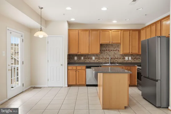 a kitchen with stainless steel appliances granite countertop a refrigerator a sink and a stove
