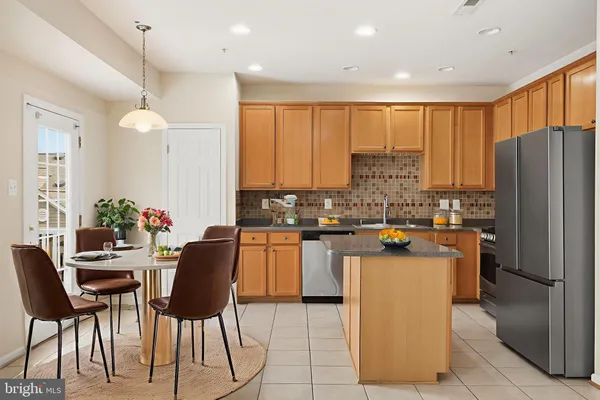 a kitchen with refrigerator and chairs