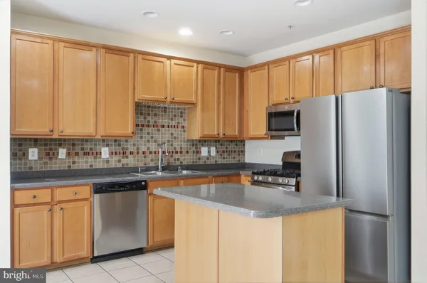 a kitchen with stainless steel appliances granite countertop a refrigerator sink and cabinets
