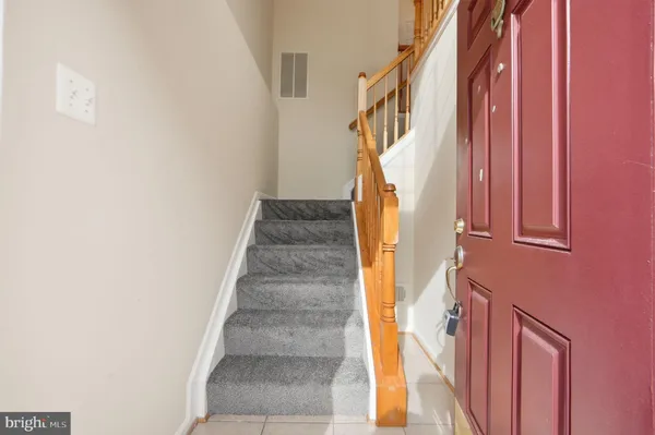a view of staircase with railing and white walls
