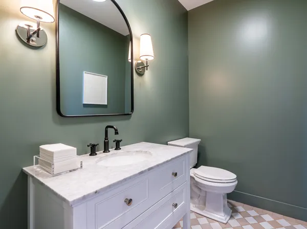 a bathroom with a toilet sink and mirror