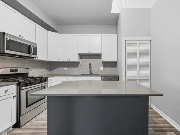 a kitchen with stainless steel appliances a sink dishwasher a stove microwave and cabinets