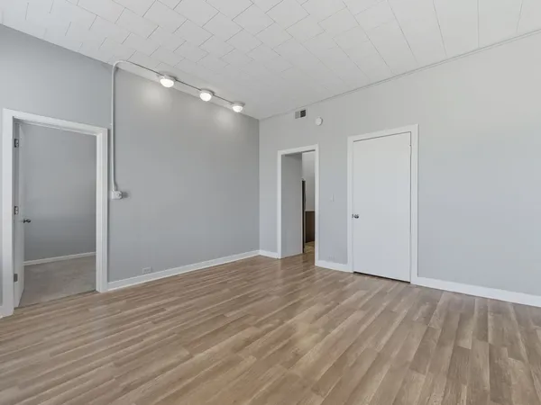 a view of an empty room with wooden floor