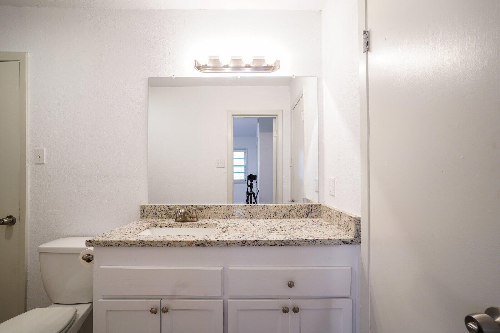 2826 54th Street Lubbock, TX 79413 - Photo 19 of 32 a bathroom with a granite countertop sink and a mirror