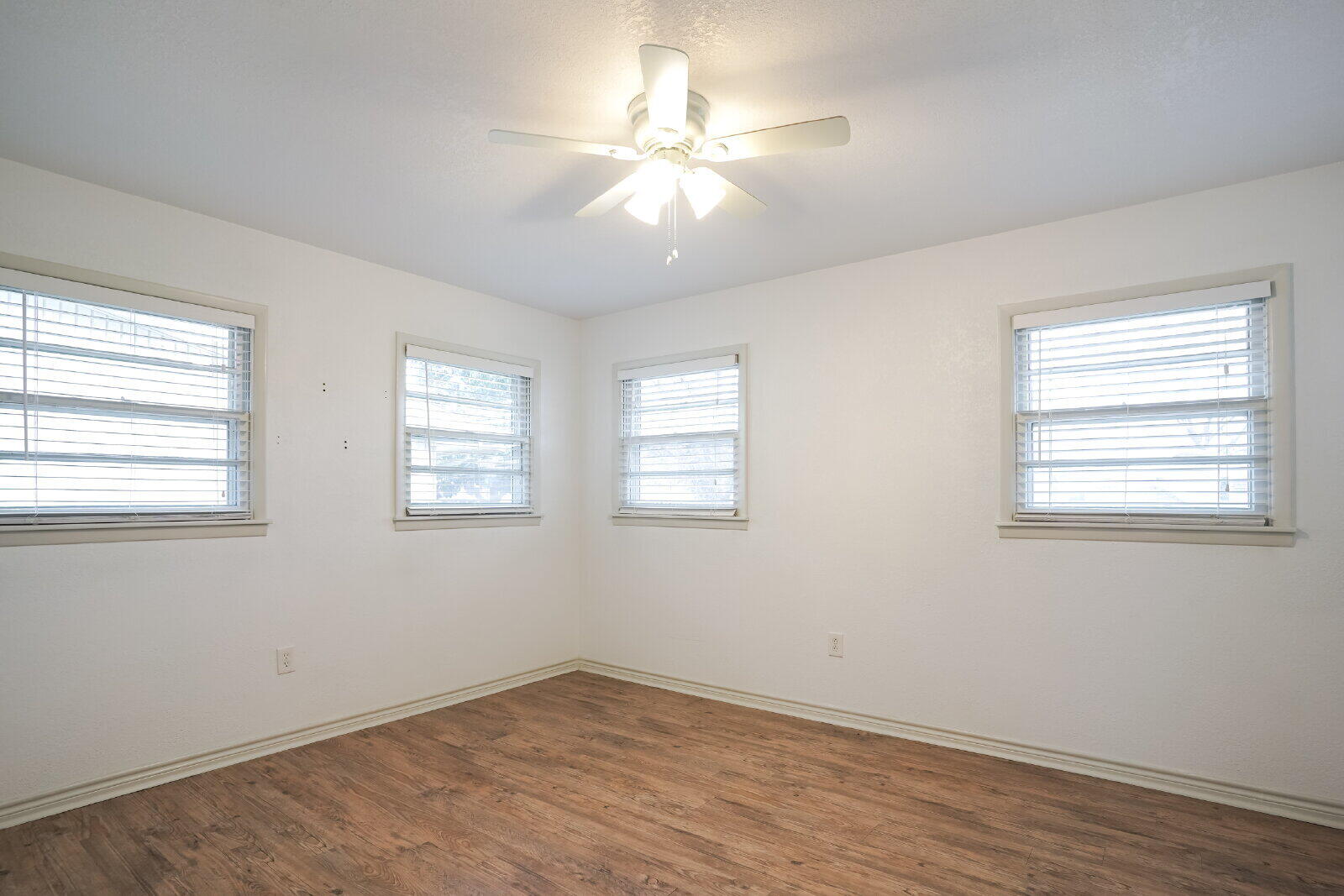 2826 54th Street Lubbock, TX 79413 - Photo 20 of 32 a view of an empty room with wooden floor and a window