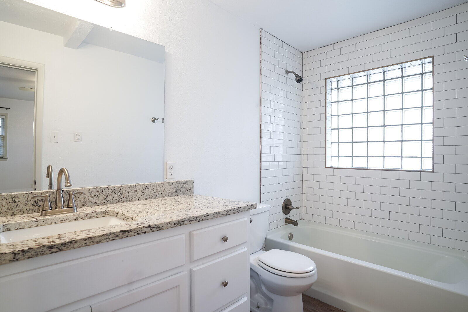 2826 54th Street Lubbock, TX 79413 - Photo 26 of 32 a bathroom with a granite countertop toilet a sink and a bathtub