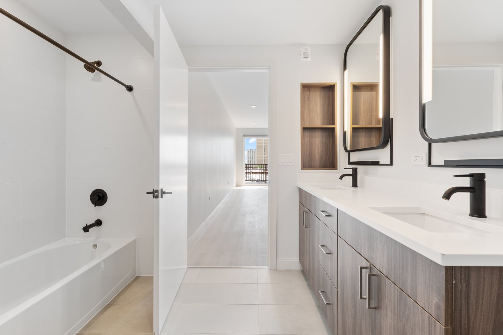 Undisclosed Address Chicago, IL 60640 - Photo 25 of 35 a bathroom with a double vanity sink a mirror and a bathtub