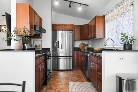 a kitchen with stainless steel appliances a sink stove refrigerator and cabinets
