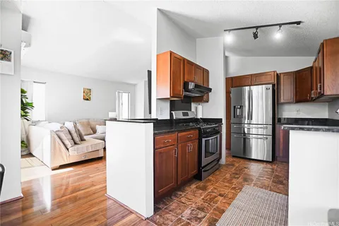 a kitchen with stainless steel appliances granite countertop a refrigerator a stove a sink and a microwave
