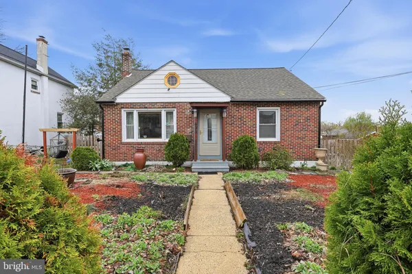 a front view of a house with a yard and potted plants