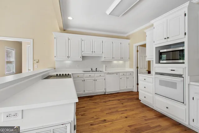 a kitchen with white cabinets and white appliances