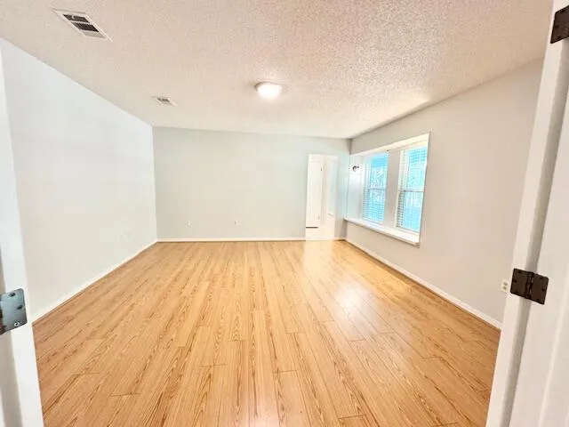 a view of empty room with wooden floor
