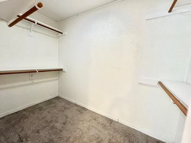 a large kitchen with stainless steel appliances a large counter top a sink a stove and a refrigerator