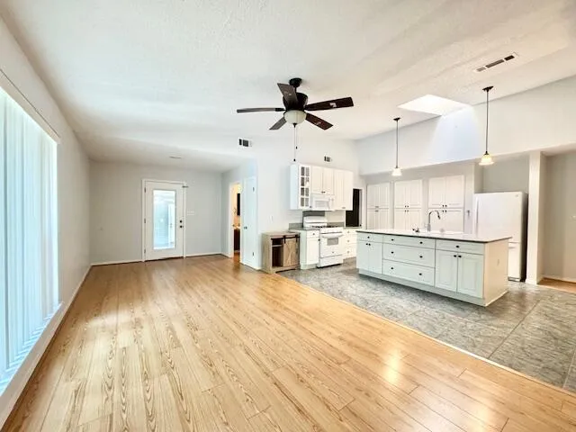 a kitchen with granite countertop white cabinets white stainless steel appliances with a sink and dishwasher
