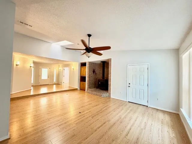 a view of a room with kitchen and wooden floor
