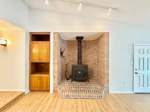 a view of a room with wooden floor and a ceiling fan