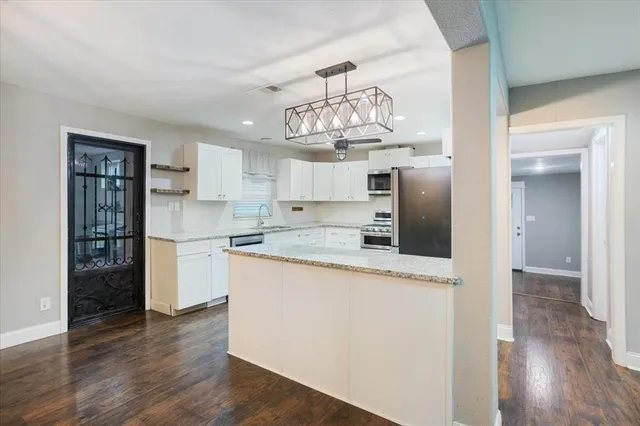 a kitchen with stainless steel appliances granite countertop a refrigerator and microwave