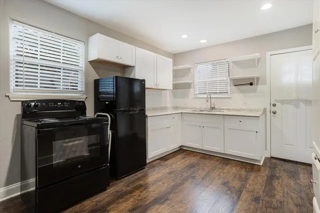 a kitchen with a refrigerator stove and wooden cabinets