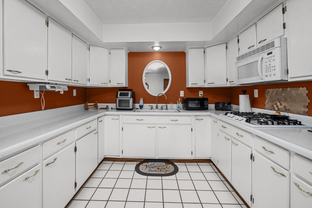 11213 22nd Street Milan, IL 61264 - Photo 26 of 36 a kitchen with white cabinets and white appliances