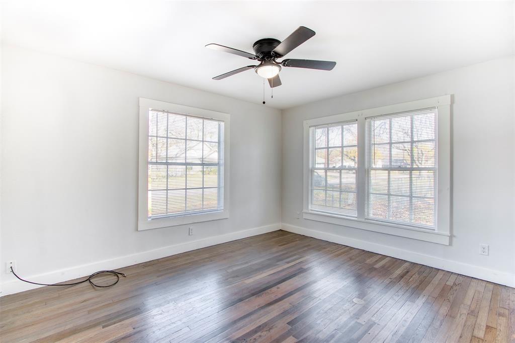 903 West 8th Street Bonham, TX 75418 - Photo 13 of 21 a view of an empty room with wooden floor and a window