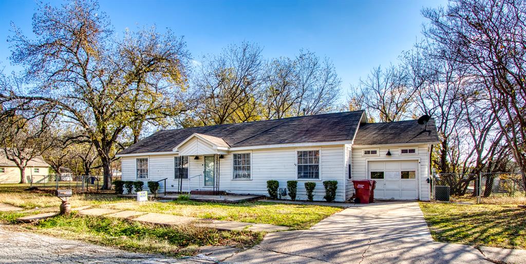 903 West 8th Street Bonham, TX 75418 - Photo 2 of 21 a view of a large pool with lawn chairs under an umbrella