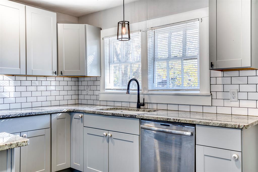903 West 8th Street Bonham, TX 75418 - Photo 8 of 21 a kitchen with stainless steel appliances granite countertop a sink a window and cabinets