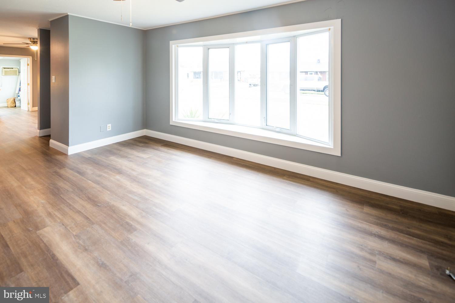 11 Carlisle Road Newark, DE 19713 - Photo 3 of 20 an empty room with wooden floor and windows