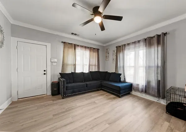 a living room with furniture and a wooden floor