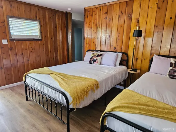 a bedroom with two beds and a window