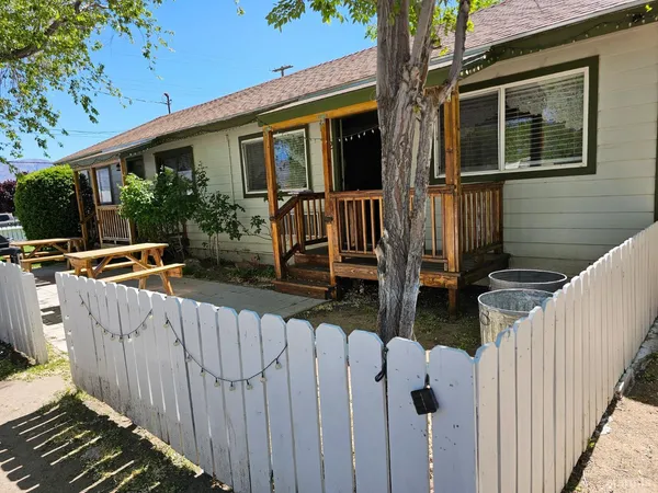 a front view of house yard with wooden fence