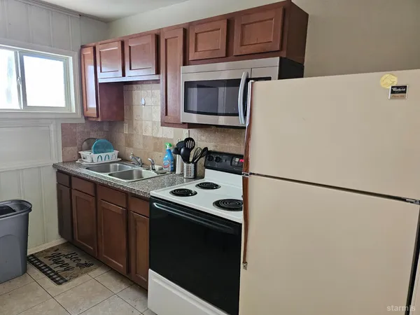 a kitchen with stainless steel appliances a refrigerator sink and cabinets
