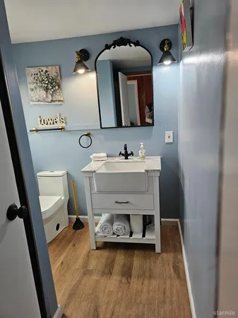 a bathroom with a toilet sink and mirror
