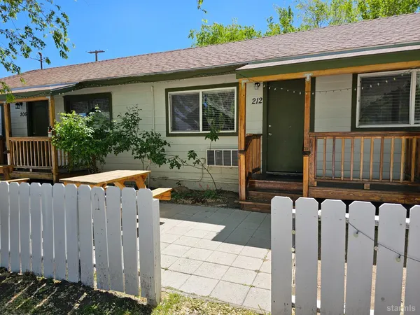 a view of a house with backyard and wooden fence