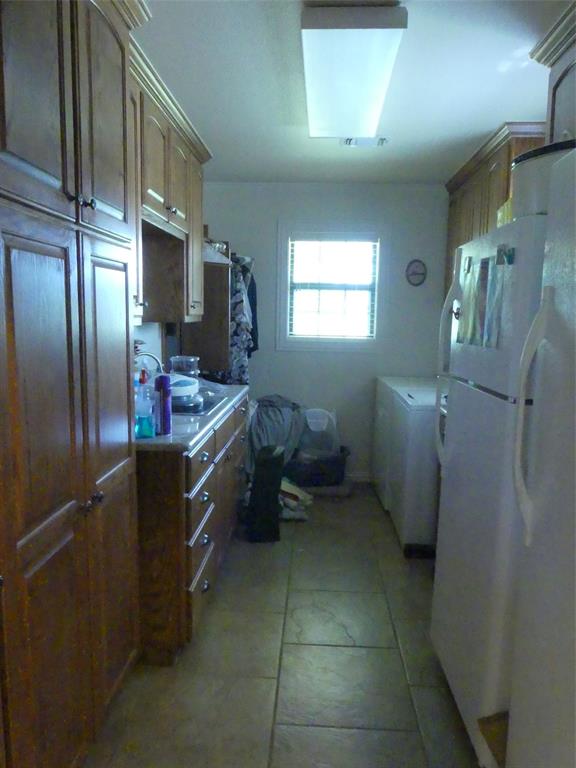 3421 Schoolhouse Road Forestburg, TX 76239 - Photo 11 of 39 a kitchen with a refrigerator sink and cabinets