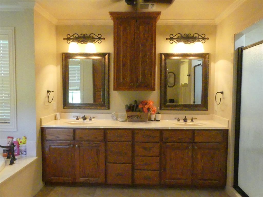 3421 Schoolhouse Road Forestburg, TX 76239 - Photo 15 of 39 a bathroom with a double vanity sink and a mirror