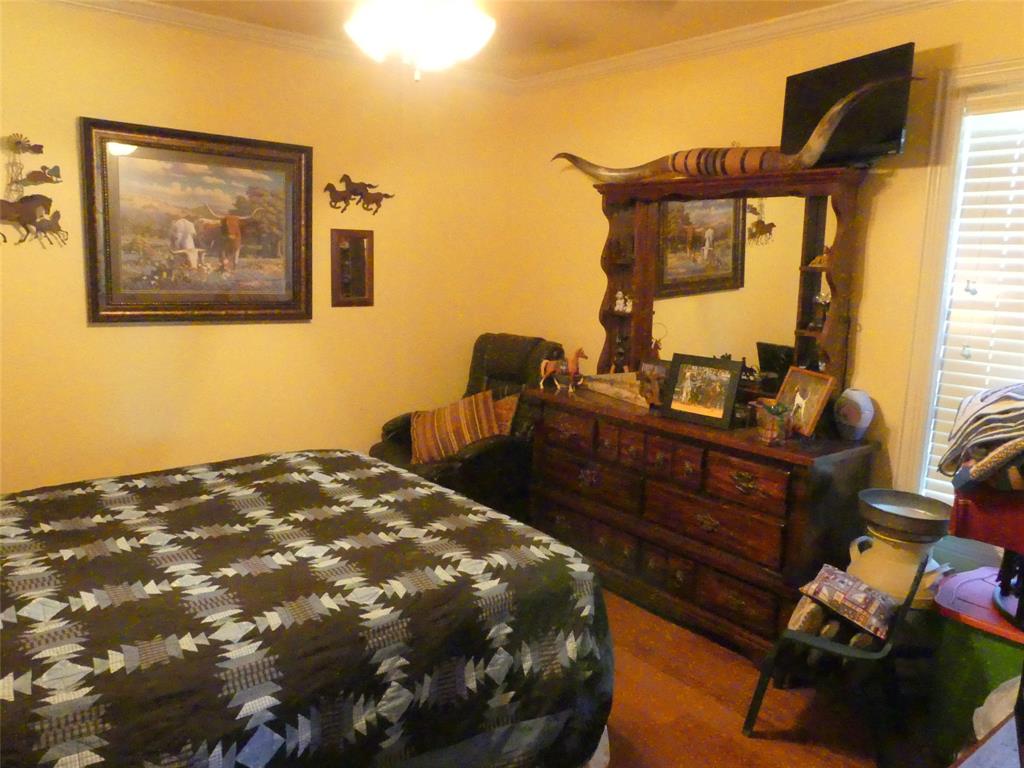 3421 Schoolhouse Road Forestburg, TX 76239 - Photo 17 of 39 a bedroom with a bed and wooden floor