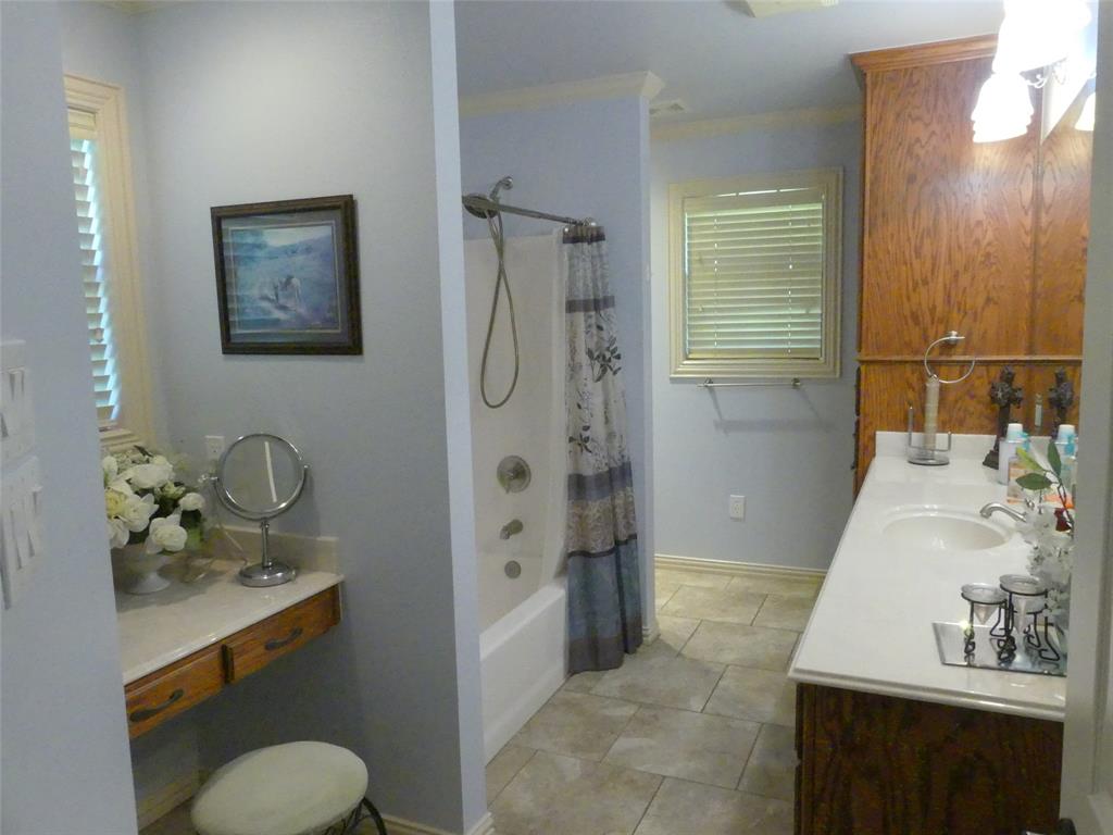 3421 Schoolhouse Road Forestburg, TX 76239 - Photo 18 of 39 a bathroom with a granite countertop sink toilet and shower