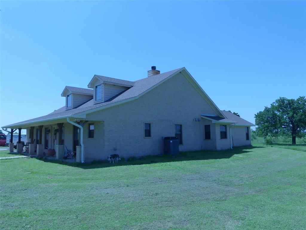 3421 Schoolhouse Road Forestburg, TX 76239 - Photo 25 of 39 a backyard of a house with wooden fence and large trees